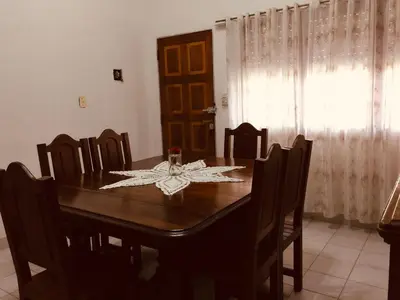 a dining room with a wooden table and chairs at Aoniken Cabañas in Villa Cura Brochero