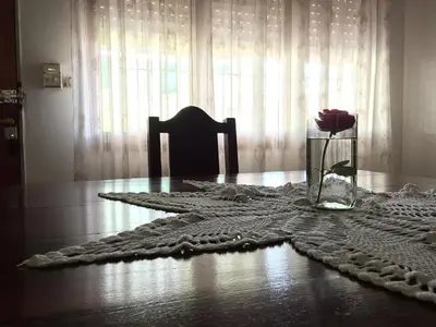 a vase of flowers on a table with a vase of roses at Aoniken Cabañas in Villa Cura Brochero
