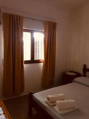 a bedroom with a bed and a window with towels at Aoniken Cabañas in Villa Cura Brochero