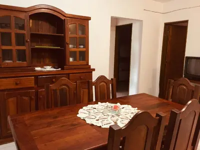a dining room with a wooden table and chairs at Aoniken Cabañas in Villa Cura Brochero
