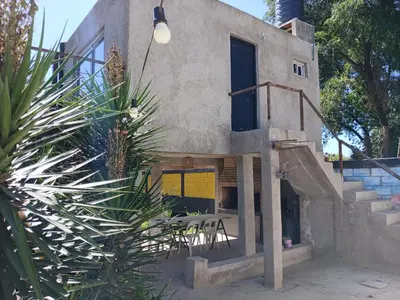 a house with stairs and a table and a plant at Hostel El Refugio de Las Aves in Santa Rosa de Calamuchita