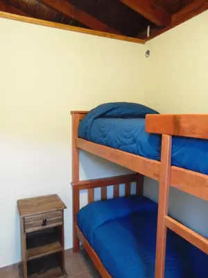 a bedroom with two bunk beds and a table at Cabañas Doña Itati in Villa Carlos Paz