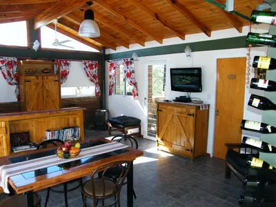 a living room with a table and a television at Cabañas Doña Itati in Villa Carlos Paz