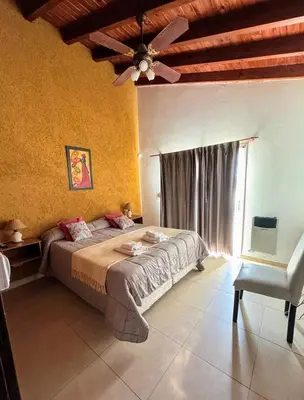 a bedroom with a bed and a ceiling fan at Departamento duplex Champaqui in Villa General Belgrano