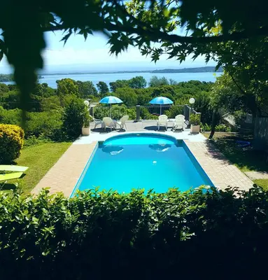 a swimming pool in a yard with chairs and umbrellas at Vistas Apart in Embalse