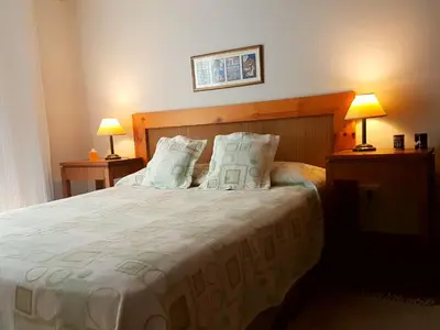 a bedroom with a large bed with two lamps at Vistas Apart in Embalse