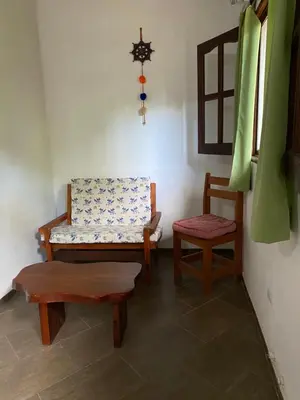 a room with a bench and a chair and a window at Cabañas el Gauchito in Los Reartes