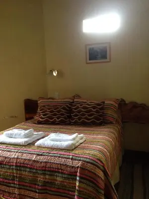 a bedroom with a bed with two towels on it at Cabañas el Gauchito in Los Reartes