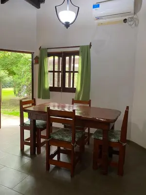 a dining room with a wooden table and chairs at Cabañas el Gauchito in Los Reartes