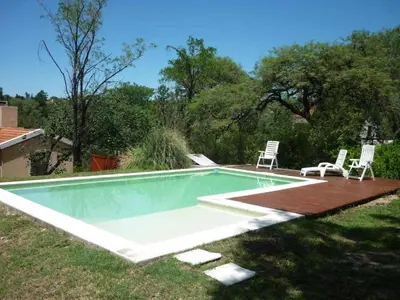 a swimming pool with two lawn chairs at El Solar in La Bolsa