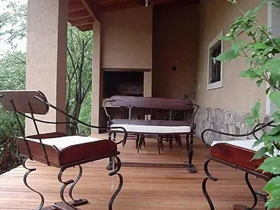 two chairs and a bench on a porch with a piano at El Solar in La Bolsa