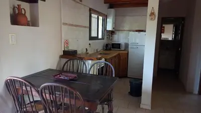 a kitchen with a table and chairs and a refrigerator at El Solar in La Bolsa
