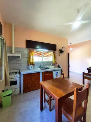 a kitchen with a wooden table and a wooden dining table at Mirador del lago apart y cabañas- exclusivo adultos in Las Rabonas