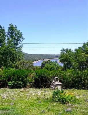 a rockolith in a field with a river in the background at Mirador del lago apart y cabañas- exclusivo adultos in Las Rabonas