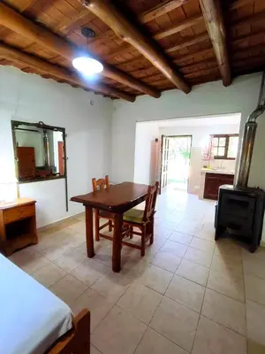a dining room with a table and a stove at Mirador del lago apart y cabañas- exclusivo adultos in Las Rabonas