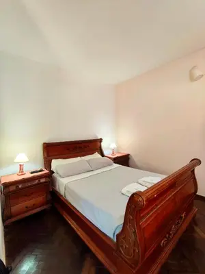 a bedroom with a wooden bed and two night stands at Mirador del lago apart y cabañas- exclusivo adultos in Las Rabonas
