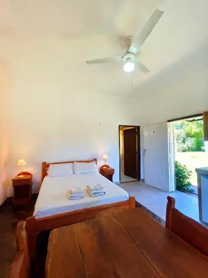 a bedroom with a bed and a ceiling fan at Mirador del lago apart y cabañas- exclusivo adultos in Las Rabonas