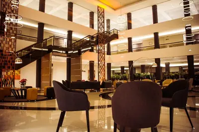 a lobby with chairs and a table and a staircase at Eleton Resort & Spa in Villa Carlos Paz