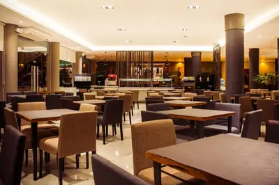 a restaurant with tables and chairs and a bar at Eleton Resort & Spa in Villa Carlos Paz
