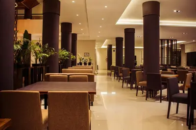 a restaurant with tables and chairs and columns at Eleton Resort & Spa in Villa Carlos Paz