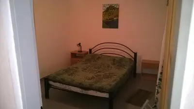 a small bedroom with a bed and a table at Departamento Carlos Paz in Villa Carlos Paz