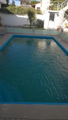 a large pool of blue water in front of a house at Departamento Carlos Paz in Villa Carlos Paz