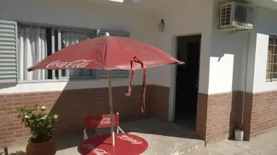 a cocacola umbrella sitting in front of a house at Departamento Carlos Paz in Villa Carlos Paz
