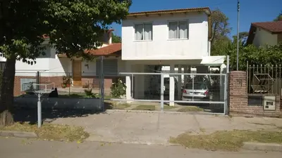 a white house with a fence in front of it at Departamento Carlos Paz in Villa Carlos Paz