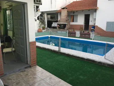 a house with a swimming pool with green grass at Departamento Carlos Paz in Villa Carlos Paz