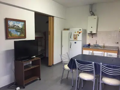 a kitchen with a table with chairs and a refrigerator at Departamento Carlos Paz in Villa Carlos Paz