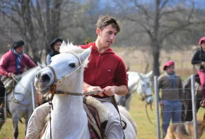 a man riding a white horse in a field at Granja El Aromo in Las Calles