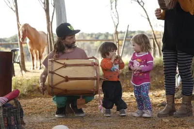 a man and two children standing next to a drum at Granja El Aromo in Las Calles