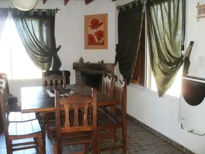 a dining room with a wooden table and chairs at Cabañas del Peñasco in Alpa Corral