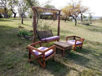 two benches and a table and a swing in a field at Cabañas del Peñasco in Alpa Corral
