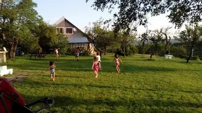 a group of children running in the grass at Cabañas del Peñasco in Alpa Corral