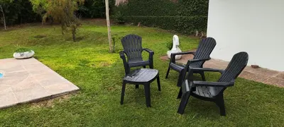 three black chairs sitting in the grass in a yard at Chalet Carlos Paz in Villa Carlos Paz