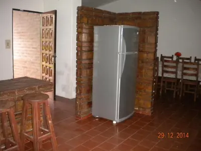 a refrigerator in a room with a brick wall at Chalet Carlos Paz in Villa Carlos Paz