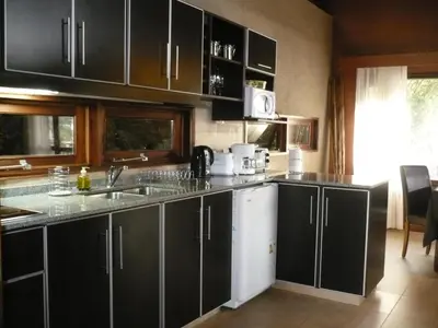 a kitchen with black cabinets and a counter top at Arroyo Escondido in La Cumbrecita