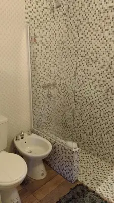 a bathroom with a shower with a toilet and a sink at Qui Home in Cordoba