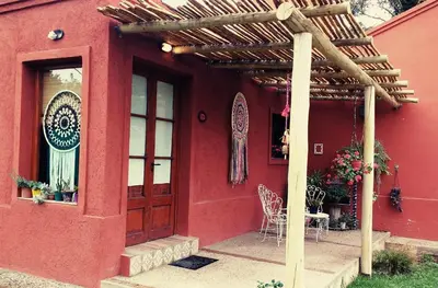 a red house with a wooden door and a patio at Qui Home in Cordoba