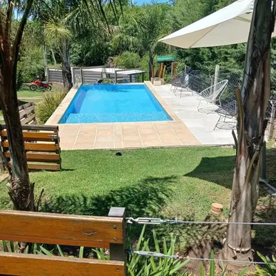 a swimming pool in a yard with a bench and an umbrella at Terralagum in Villa Parque Siquiman