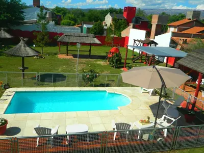 an overhead view of a pool with chairs and an umbrella at La Posada Del Poeta in Mina Clavero