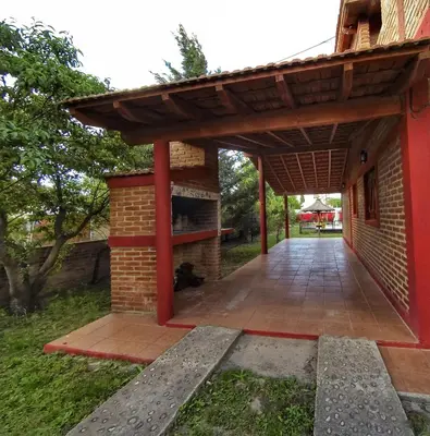 an outdoor patio with a brick building with a roof at La Posada Del Poeta in Mina Clavero
