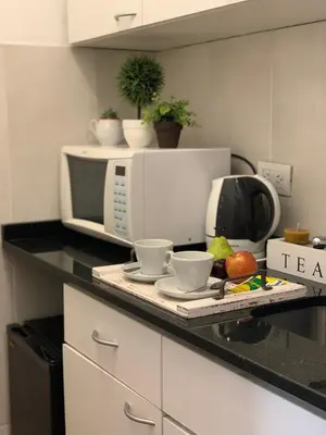 a kitchen counter with a microwave and some cups at Novum Suites in Cordoba
