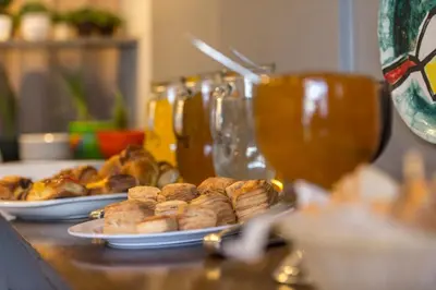 two plates of pastries on a table with a glass of wine at Novum Suites in Cordoba