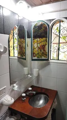 a bathroom with a sink and three stained glass windows at Posada de Nono in Nono