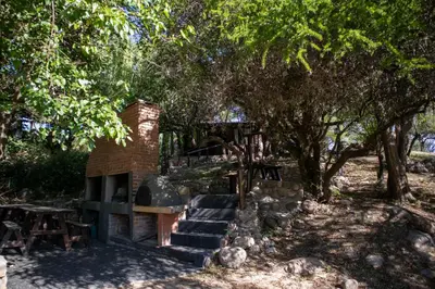 a brick fireplace in a park with trees at Posada de Nono in Nono