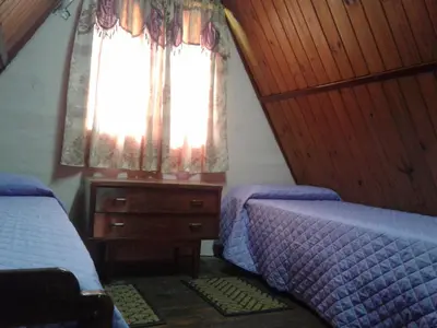 a bedroom with two beds and a window at Cabanas Junto al Rio in Panaholma