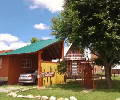 a house with a tree and a sign in front of it at Cabanas Junto al Rio in Panaholma