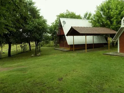 a house with a pavilion next to a grass yard at Cabanas Junto al Rio in Panaholma